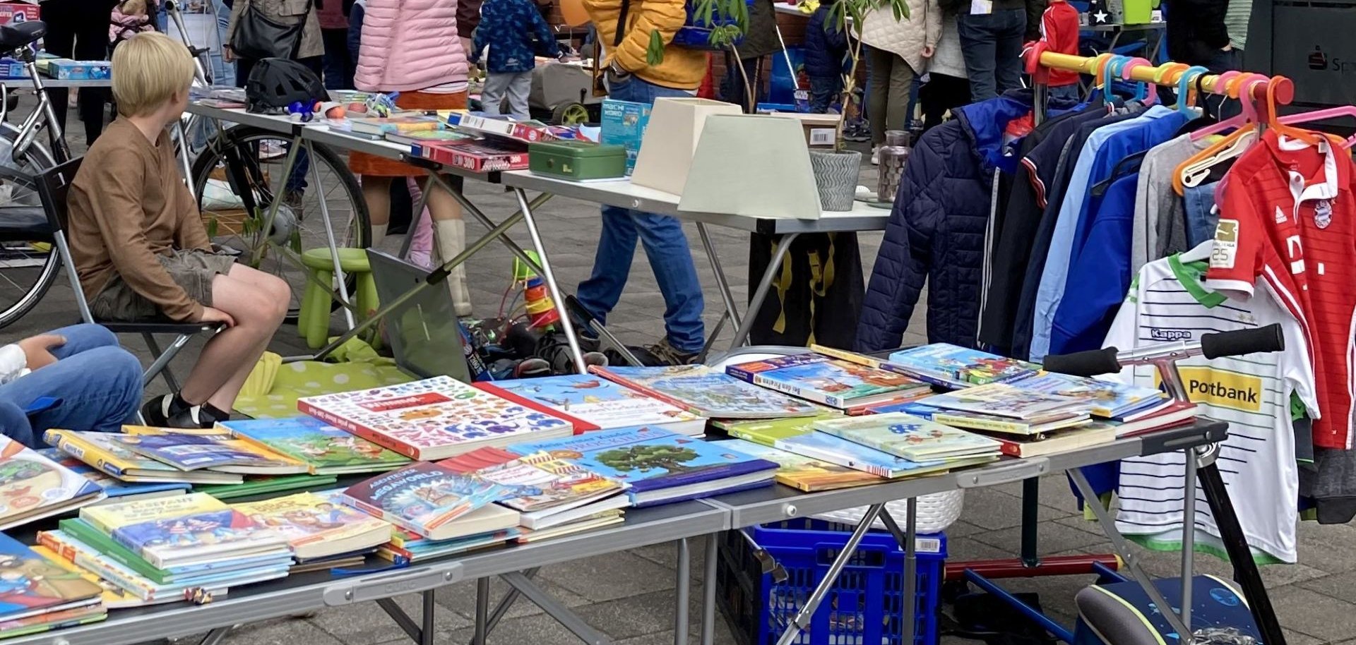 Ein Stand mit Kinderbüchern und Kleidung auf dem Kinderflohmarkt