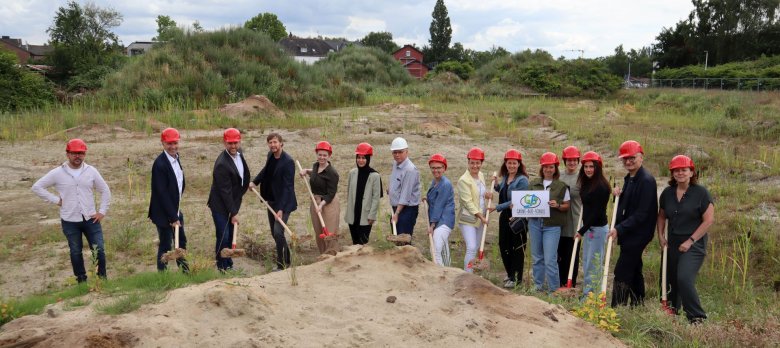 Eine große Gruppe mit roten Helmen auf der Baustelle an der Marschallstraße Eine große Gruppe mit roten Helmen auf der Baustelle an der Marschallstraße