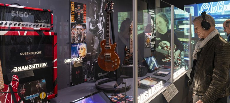 Besucher stehen vor Ausstellungsstücken der "Guitar Heroes" Sonderausstellung