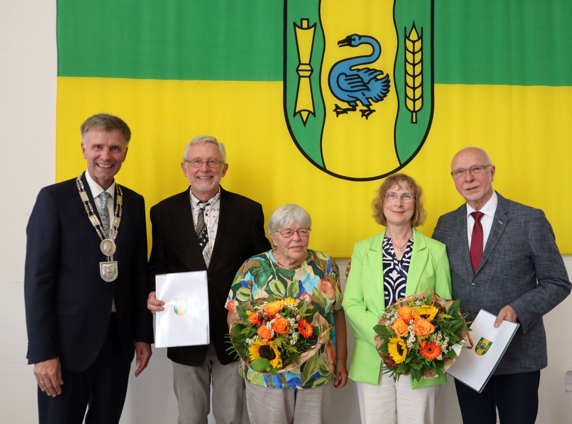 Bürgermeister Rainer Doetkotte mit den Geehrten Georg Gartmann und Franz Josef Terlinde und den Ehepartnern im Ratssaal vor der Gronauer Fahne