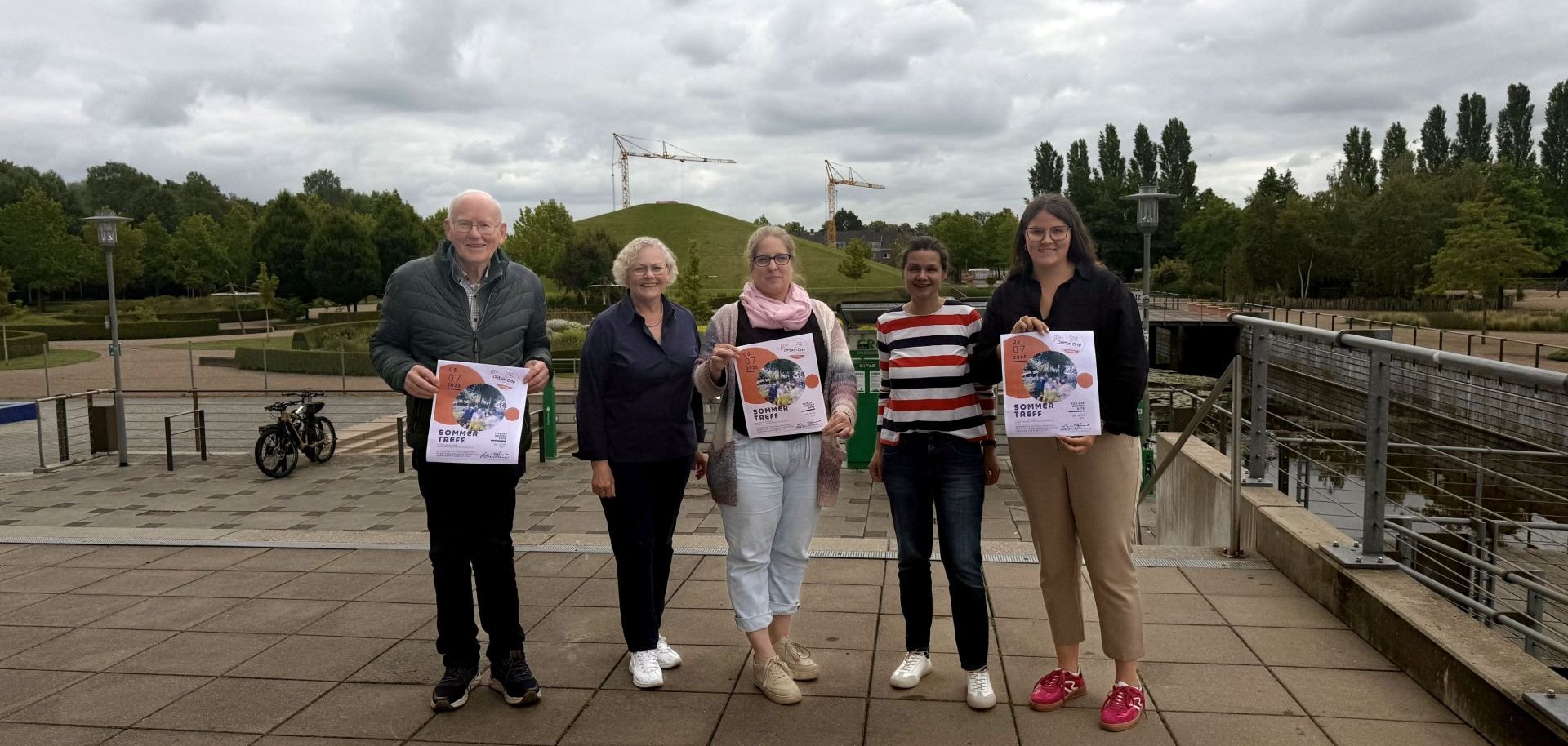 Fünf Personen präsentieren Plakate.