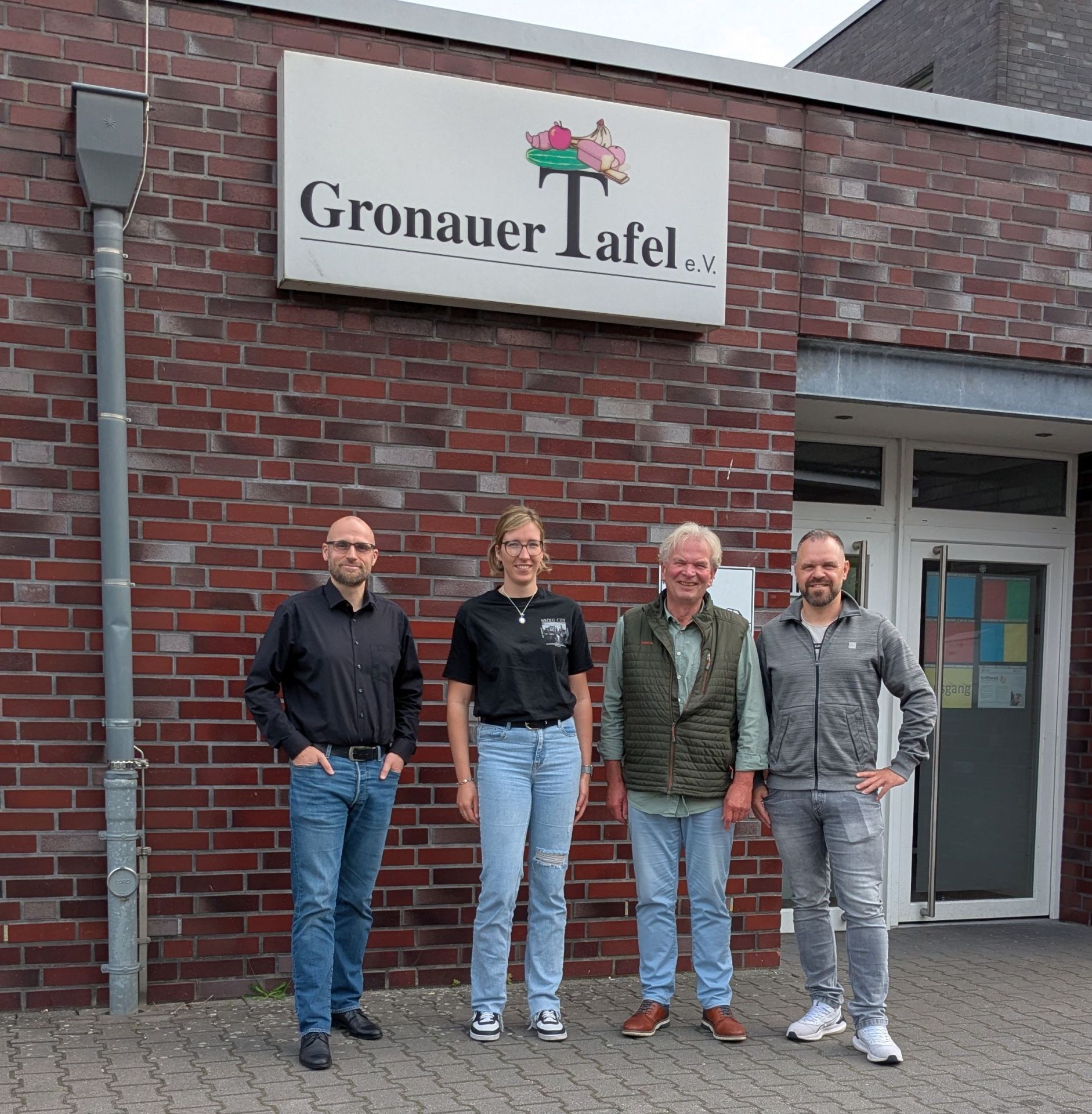 Vertreter:innen des Team Integration mit dem 1. Vorsitzenden der Gronauer Tafel vor dem Gebäude der Gronauer Tafel