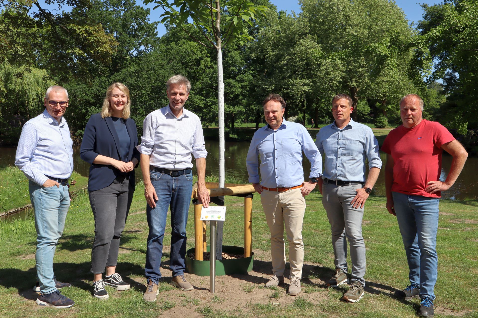 Gruppe von Menschen im Stadtpark Gronau mit einer Eßkastanie