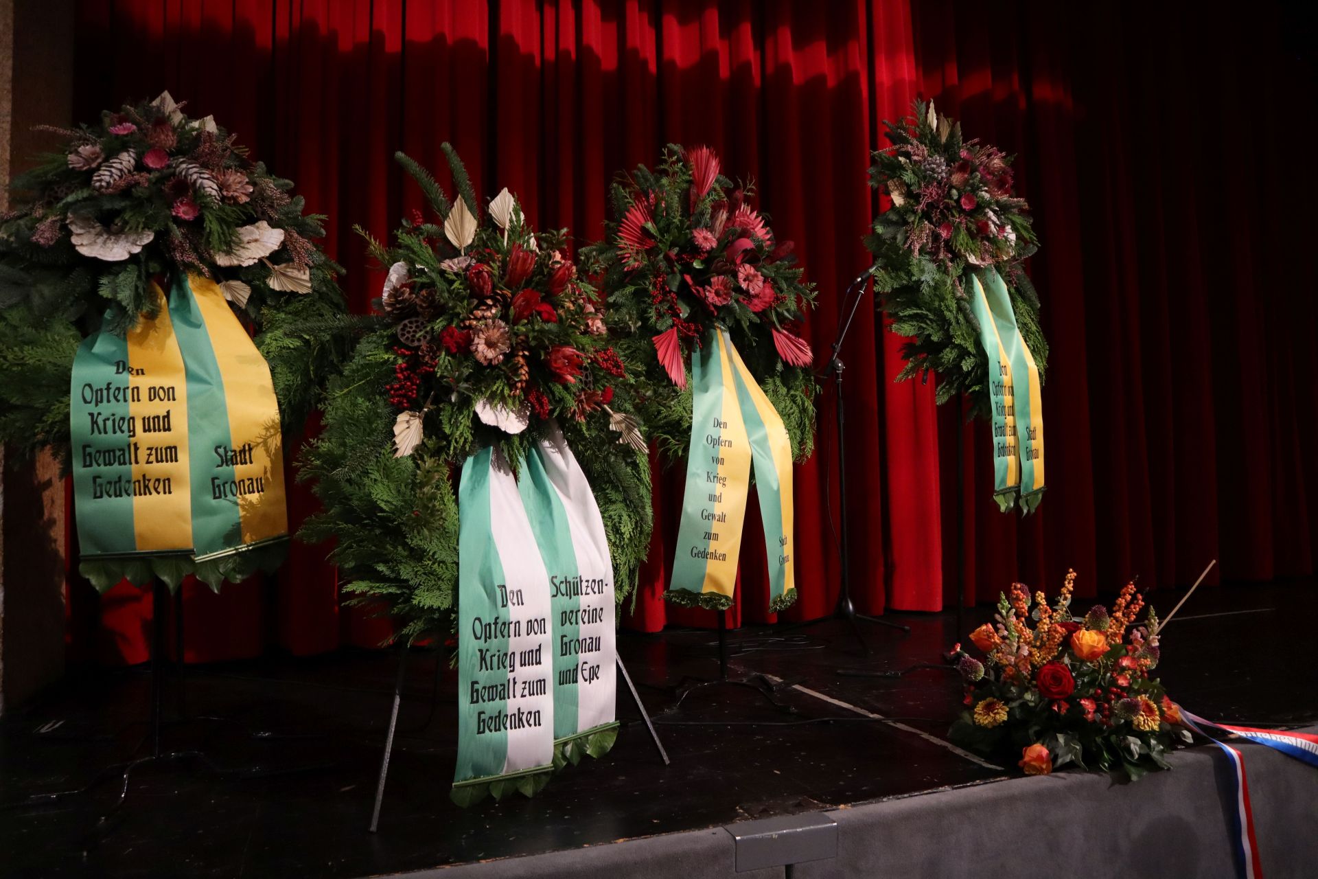 Kränze und Gestecke auf der Bühne der Aula