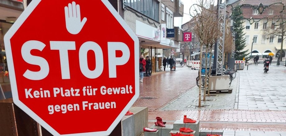 Rote Schuhinstallation neben einem Stoppschild mit der Aufschrift ‚Kein Platz für Gewalt gegen Frauen‘ Rote Schuhinstallation neben einem Stoppschild mit der Aufschrift ‚Kein Platz für Gewalt gegen Frauen‘