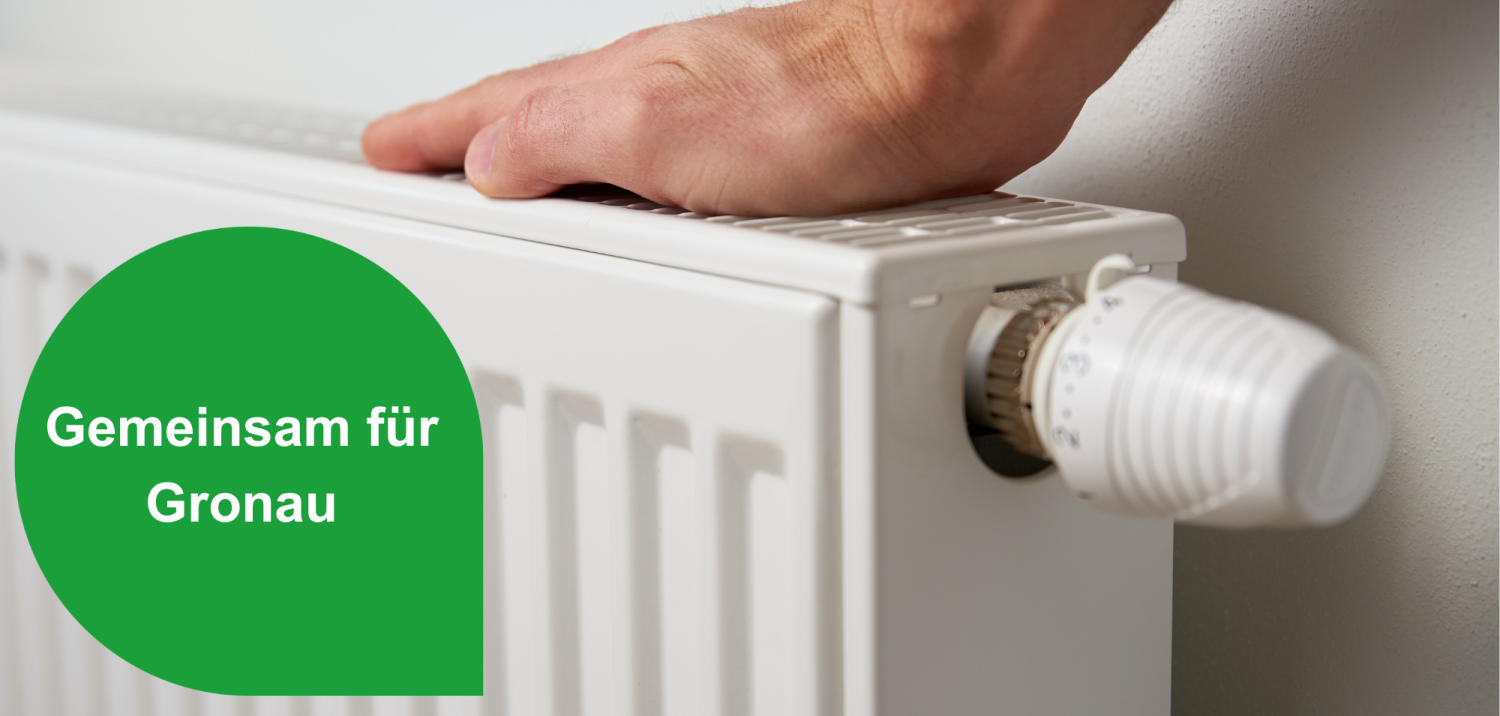 Hand auf einer Heizungsoberfläche mit dem Hinweis ‚Gemeinsam für Gronau‘