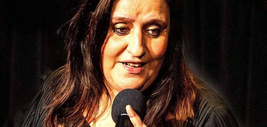 Die Sängerin Anneke van Wassenhove mit einem Mikrofon