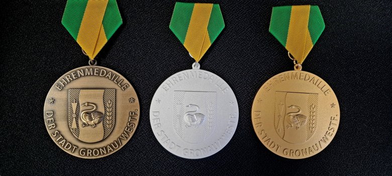 Das Bild zeigt Ehrenmedaillen in Bronze, Silber und Gold, die für langjährige Ratstätigkeit überreicht wurden.