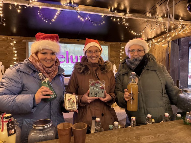 Ein Stand auf dem Weihnachtsmarkt in Gronau Drei Personen verkaufen selbstgemachte Dekorationen und selbstabgefüllte Getränke auf dem Weihnachtsmarkt in Gronau.