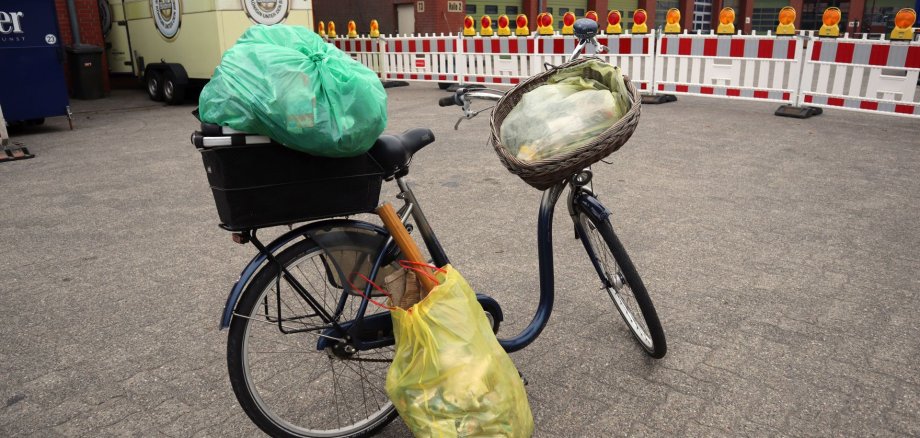 Voll beladen für den guten Zweck: Eine Bürgerin sammelt Müll in der Stadt und bringt ihn mit dem Fahrrad zu den Zentralen Bau- und Umweltdiensten.